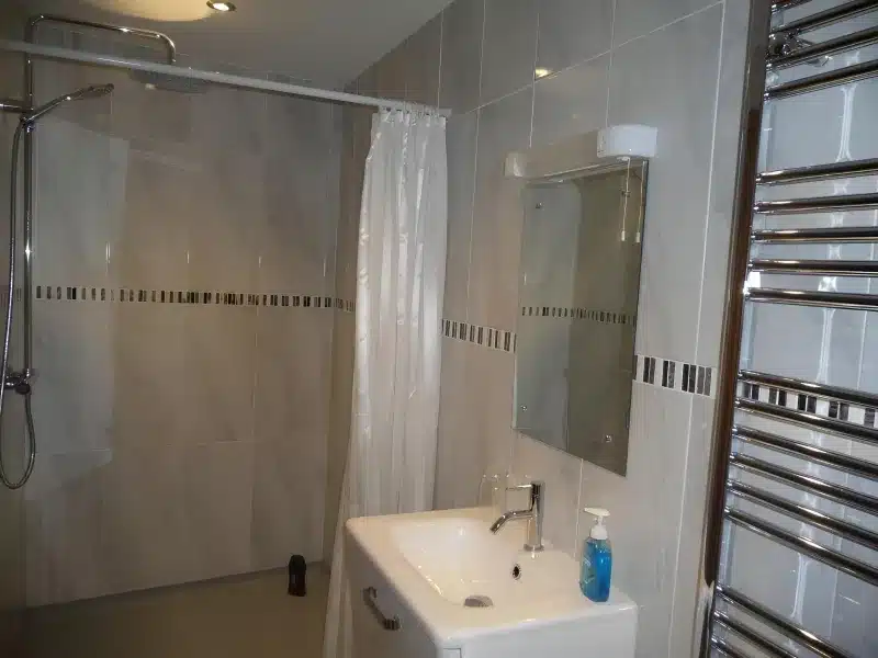 Ground-floor twin’s tiled wet room with shower curtain