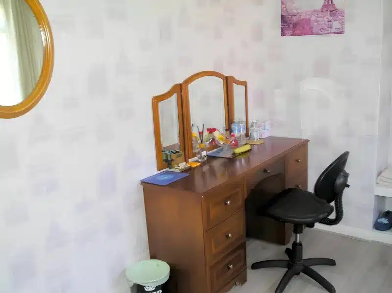A wooden dressing table with a folding mirror and a desk chair at Liverpool Airport Rooms.