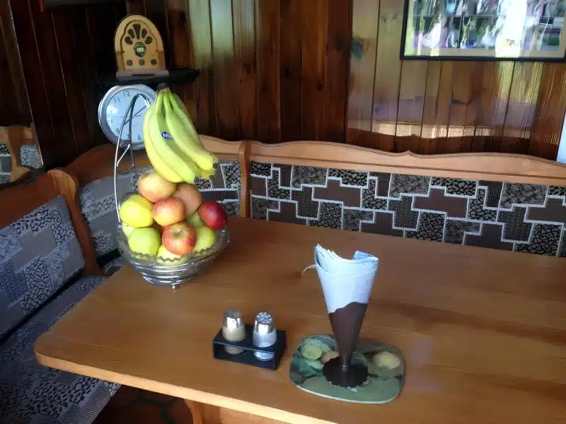 A fruit bowl on a wooden table in the dining area at Liverpool Airport Rooms.