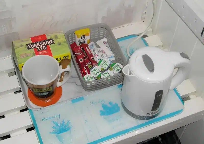Tea, coffee sachets and a kettle on a tray in the room at Liverpool Airport Rooms.