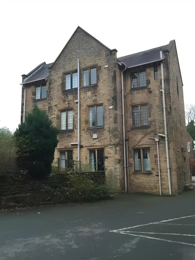 A marked car park in front of the stone guest house.