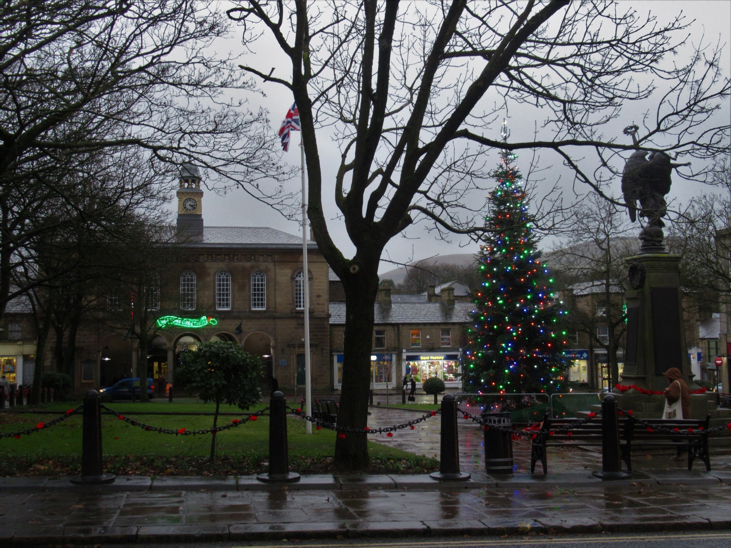 Norfolk Square in Glossop on a wet December day, with the town hall clock, a Christmas tree, and the war memorial.