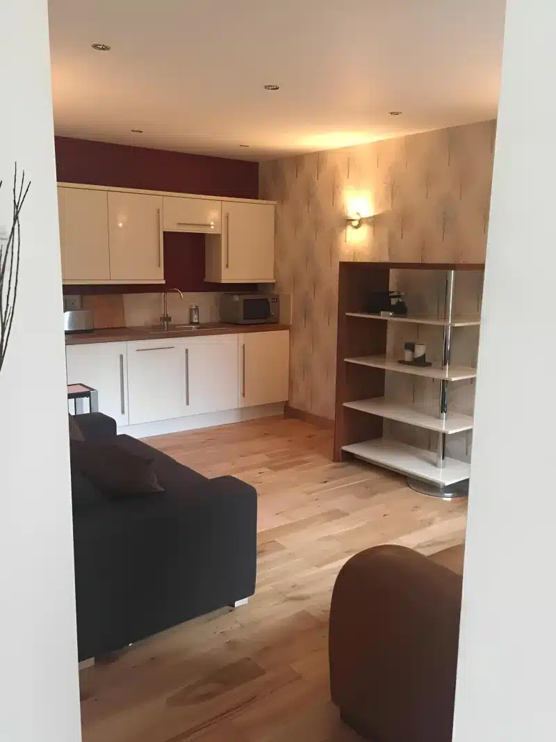 View from the hall into the kitchen, sofa and open shelves.