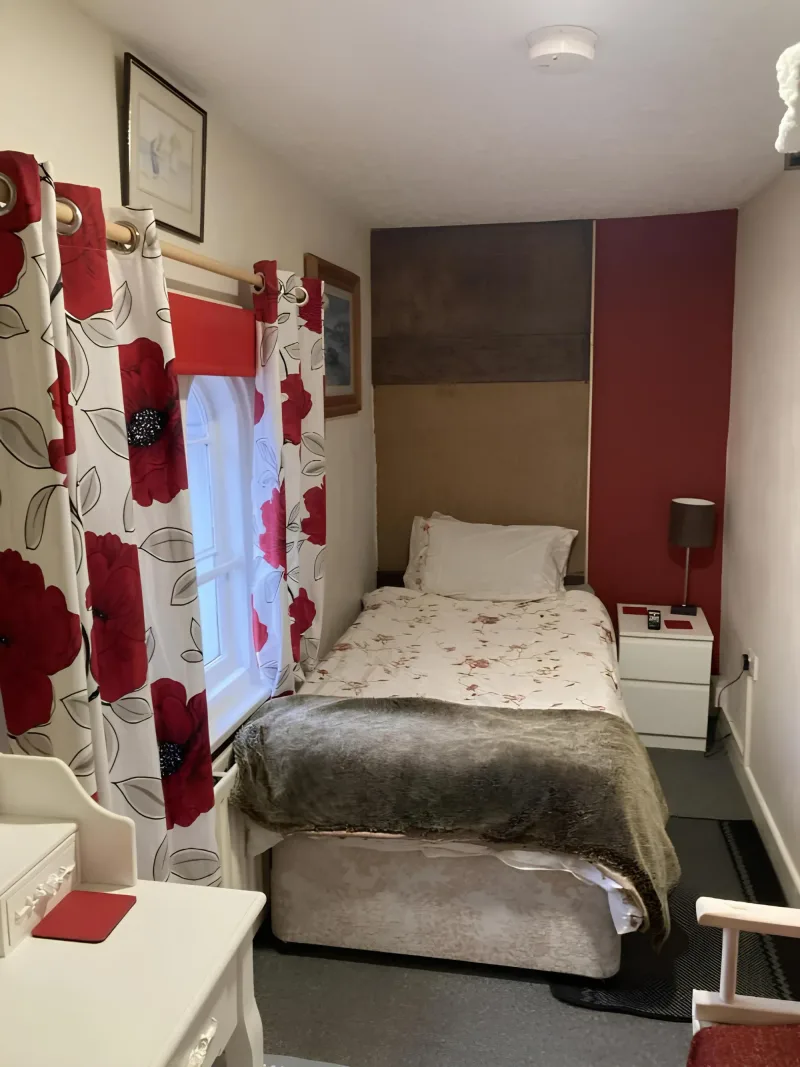 Bedroom with red and white patterned curtains