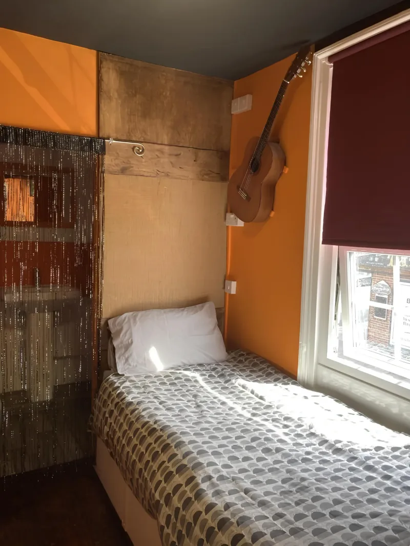Small bedroom with orange walls