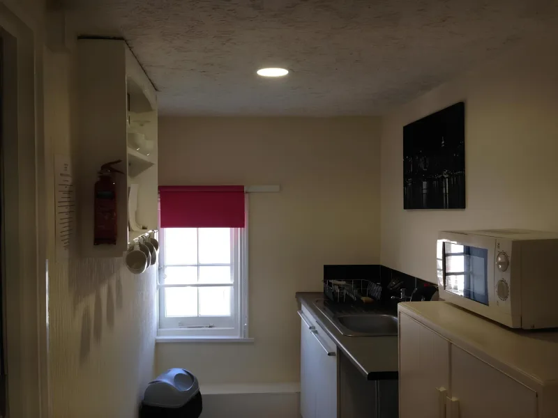 Shared kitchenette with microwave, fridge and window