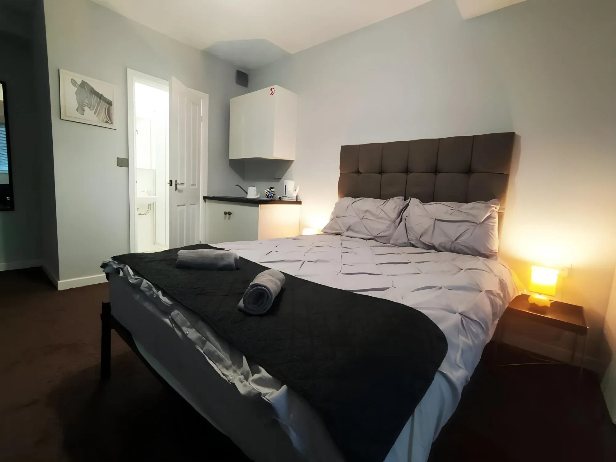 Double bedroom with bedside lights and an open private bathroom doorway at Bankwell Guest House