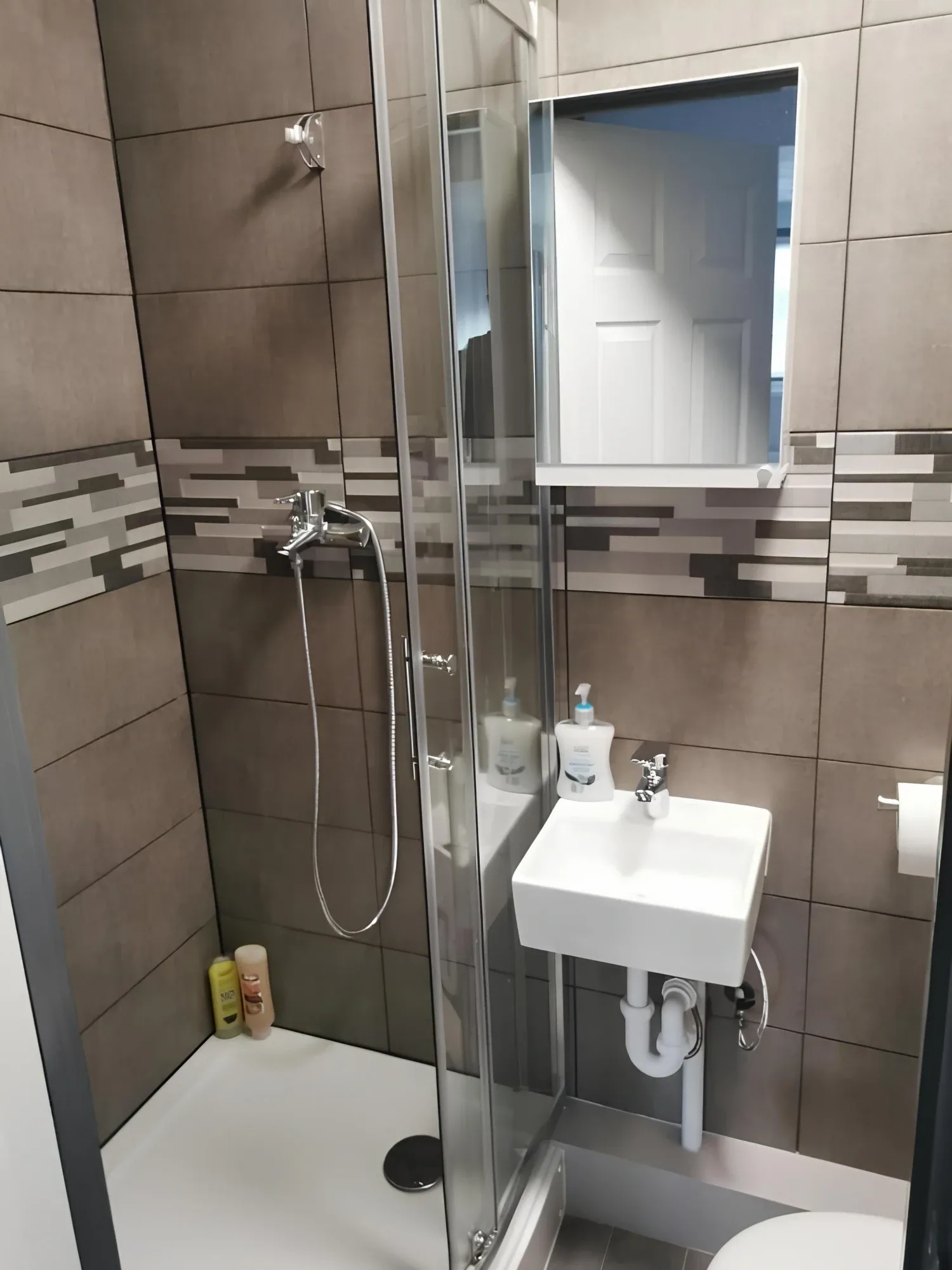 Shower, washbasin and mirror in the bathroom associated with the Double or Twin room