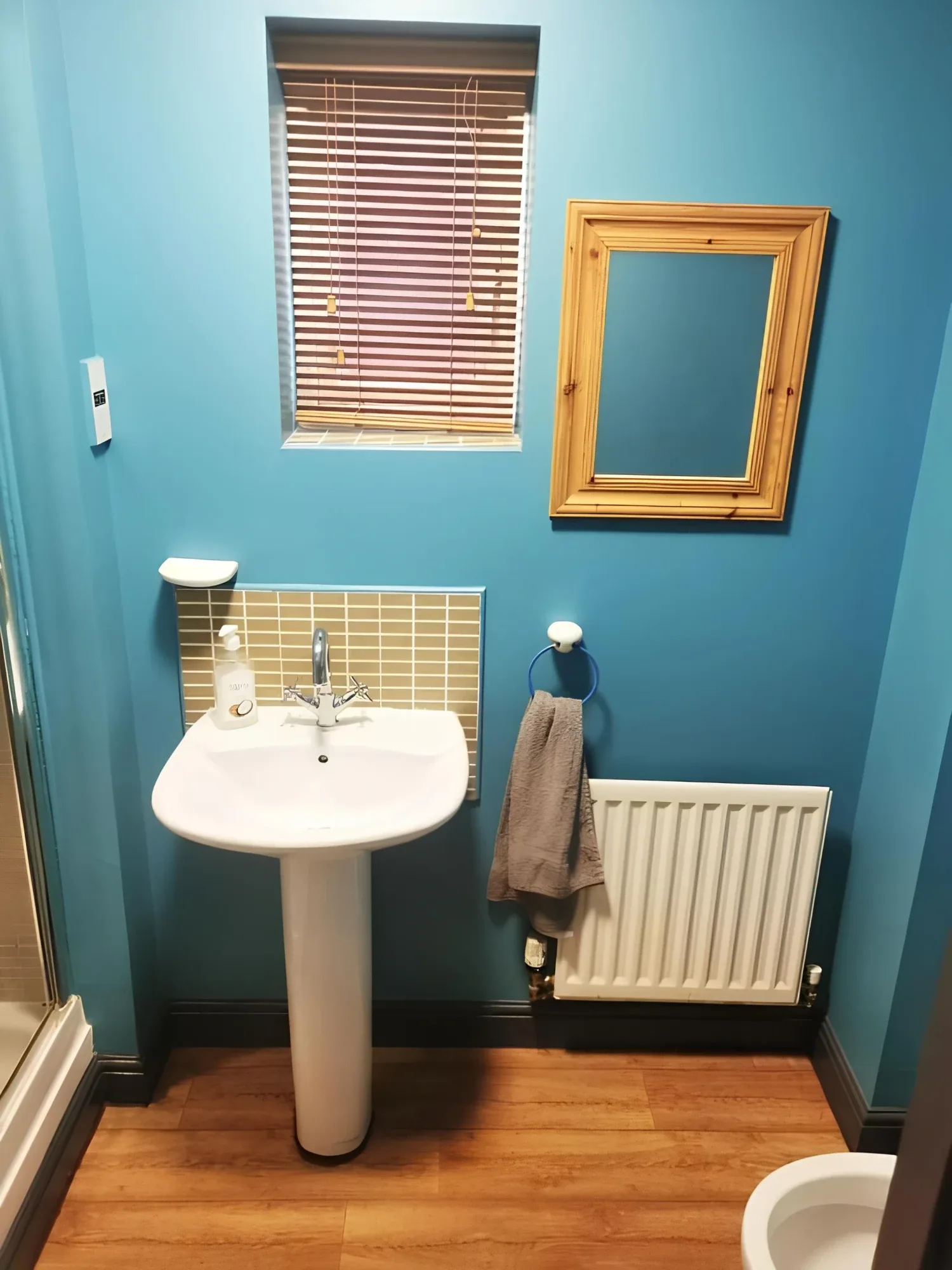 Washbasin and mirror against a teal wall in the bathroom associated with the Family Room