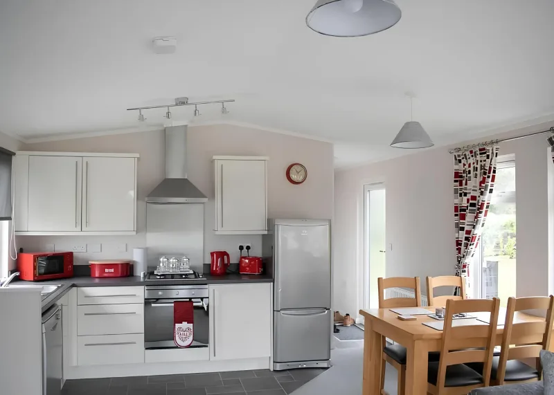 White kitchen cabinets, oven and dining table