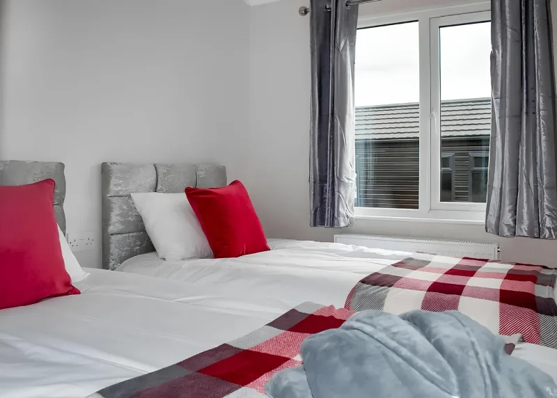 Twin beds with red and grey bedding