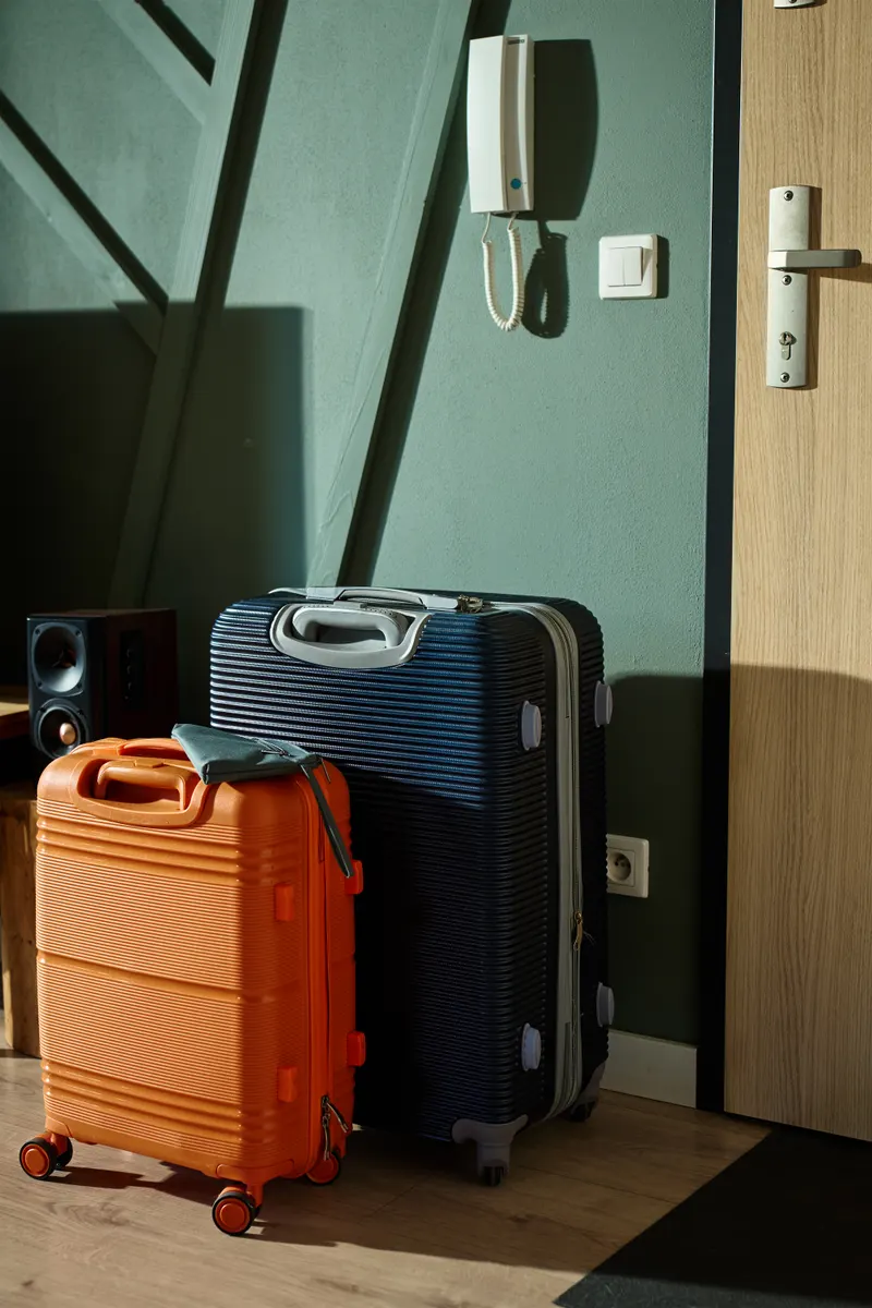 Illustrative travel suitcases beside a doorway